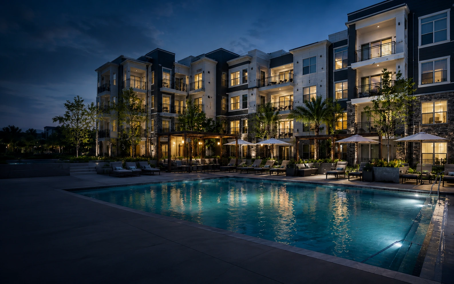 Twilight exterior of a luxury apartment community with a pool, used as the FirstService Residential case study background